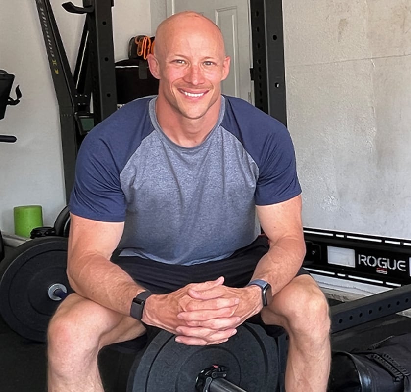 Coach is sitting on his workout room ans smiling